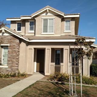 A two-story suburban house with a stone and stucco exterior.