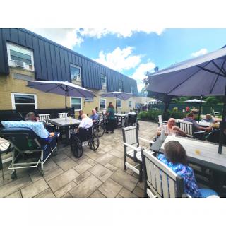 A lively outdoor cafe scene with people enjoying the sunny weather.