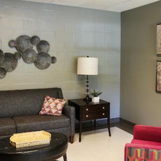 A cozy living room space featuring a stylish sofa, a modern lamp, and decorative wall art.