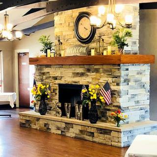 A beautifully decorated stone fireplace with flowers and a clock, enhancing the cozy room ambiance.