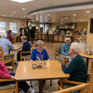 Seniors enjoying a social gathering in a communal dining area.
