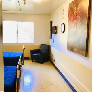 A cozy room with a bed, chair, and wall decorations.