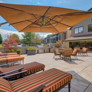 A spacious outdoor patio with comfortable seating and large umbrellas, perfect for relaxation.