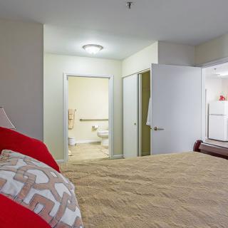 A cozy bedroom with view into an adjoining bathroom.