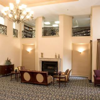 An elegant lobby with a chandelier, fireplace, and comfortable seating.