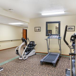 A small gym with fitness equipment including a treadmill and an exercise bike.