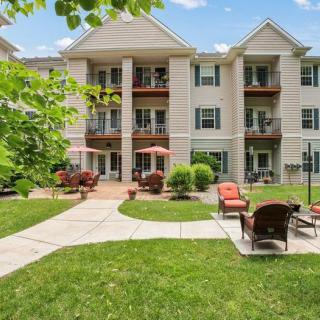 A modern apartment building with a landscaped outdoor area featuring patio furniture.