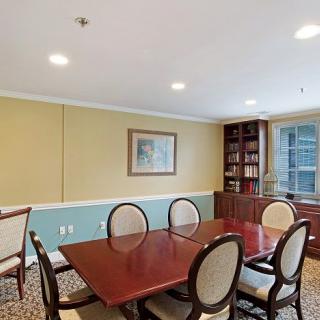 A well-appointed conference room with a large wooden table, several chairs, and a built-in bookshelf.