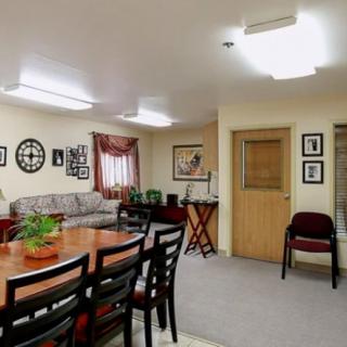 A cozy room with a dining table and chairs, a sofa, and wall decor.