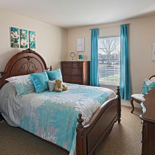 A cozy bedroom with a wooden bed frame and turquoise accents.