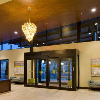 A modern lobby entrance featuring a chandelier and glass doors.