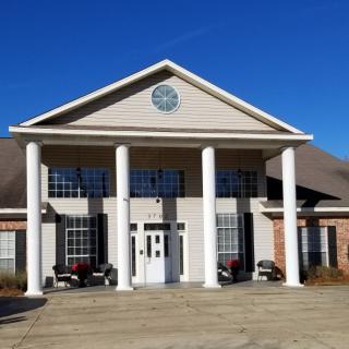 A symmetrical building with large columns at the entrance under a clear blue sky.