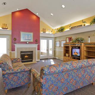 A cozy living room with a fireplace, sofas, and a TV.