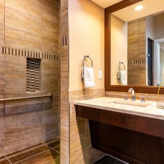 A modern bathroom featuring a spacious shower, elegant sink, and stylish mirror.