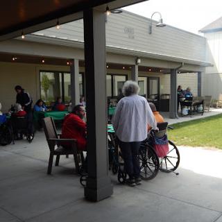Seniors enjoying a sunny day at a community center, engaging in social activities.