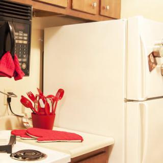 A kitchen with red-accented utensils and appliances.