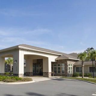 A commercial building with a covered entrance and surrounding landscaping.