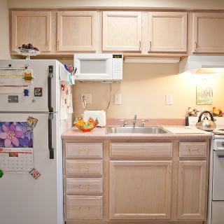 A compact kitchen space with wooden cabinets and essential appliances.