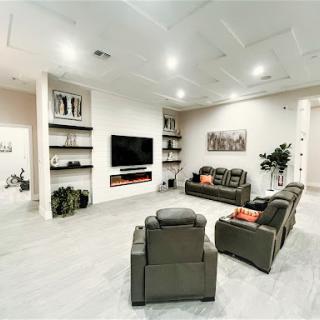 A modern living room featuring comfortable seating and a sleek entertainment setup.