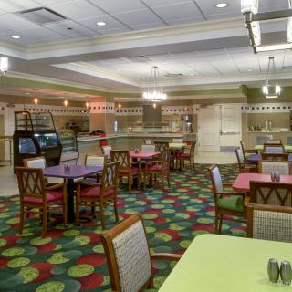 A colorful and spacious restaurant dining area with empty tables and chairs.