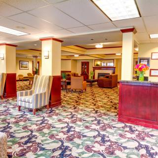 A spacious hotel lobby with patterned carpet and comfortable seating.