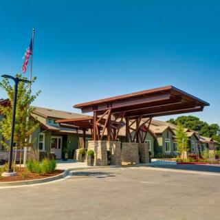 A well-designed building entrance with a large awning and landscaped surroundings.