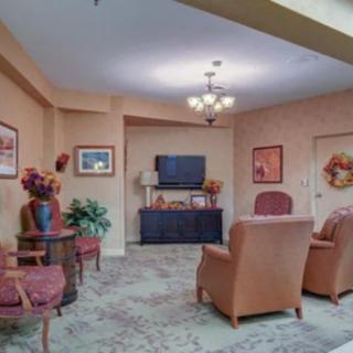 A cozy living room with comfortable seating and a television, featuring traditional decor.