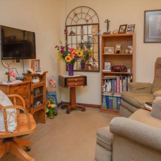 Cozy living room with a bookshelf, TV, and comfortable seating.