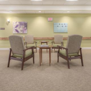 A quiet waiting room with four chairs arranged around a small table.