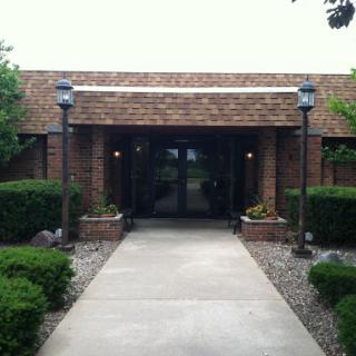 Entrance of a brick building with landscaped surroundings.