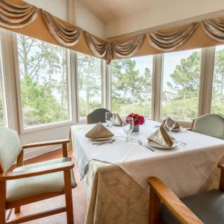 A beautifully set dining table in a cozy restaurant with scenic views.