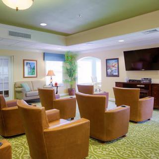 A cozy living room with multiple armchairs facing a television.