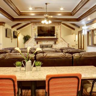 Luxurious living room with a spacious seating area, large television, and elegant fireplace.