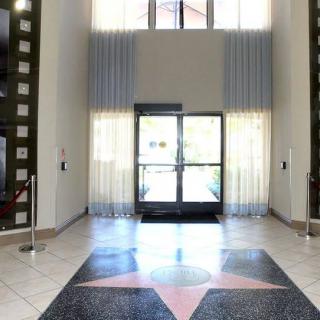 A well-lit lobby entrance with glass doors and a star design on the floor.
