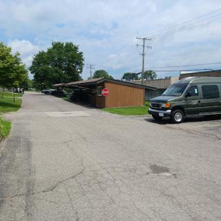 A quiet street scene featuring a parked van and surrounding greenery.