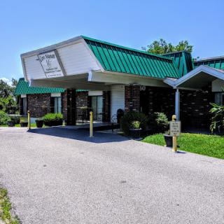 A commercial building with a green roof and landscaped surroundings.