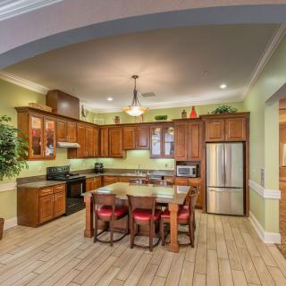 A cozy kitchen with wooden cabinets, green walls, and modern appliances.