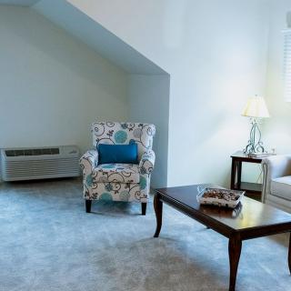 A cozy living room with an armchair, coffee table, and lamp.