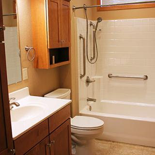 A clean and modern bathroom featuring a shower, toilet, and vanity with storage.
