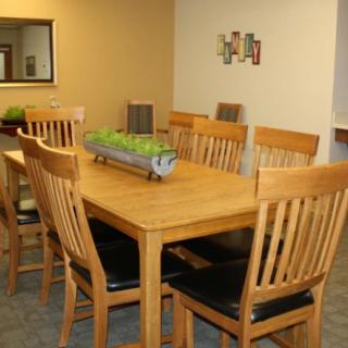 A cozy dining room with a wooden table and chairs, adorned with a decorative centerpiece.