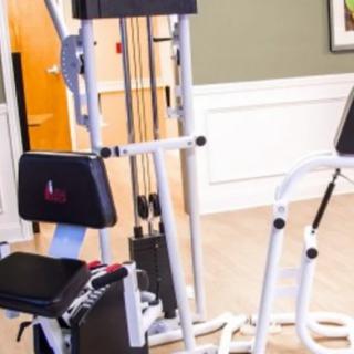 A multi-station exercise machine in a fitness room.