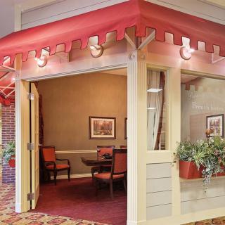 A cozy restaurant interior with a red awning and potted plants.