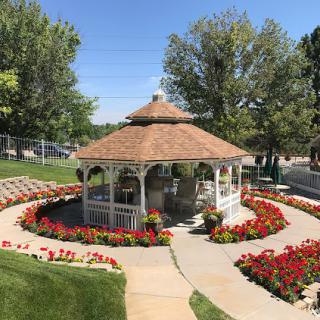 A beautiful garden featuring a gazebo surrounded by vibrant flowers and lush greenery.