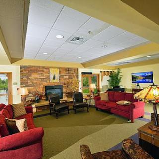 A cozy living room with comfortable seating, a television, and indoor plants, perfect for relaxation.