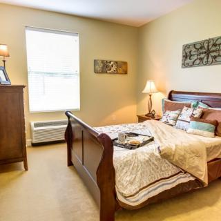 A cozy and well-lit bedroom featuring elegant furniture and warm decor.