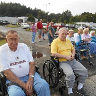 A group of elderly individuals in wheelchairs enjoying time outdoors.