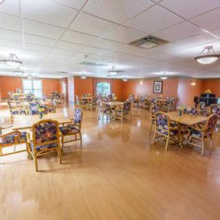 A spacious dining area with multiple tables and chairs, designed for community gatherings.
