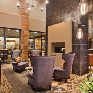 A modern hotel lobby with stylish seating and a cozy fireplace.