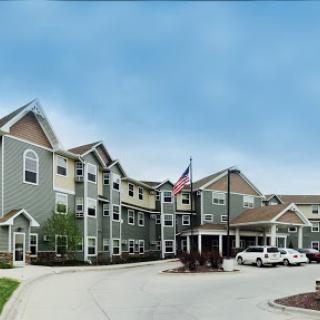A modern hotel exterior featuring a welcoming entrance and an American flag.