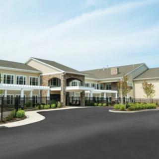Modern residential building with landscaped surroundings and a spacious driveway.